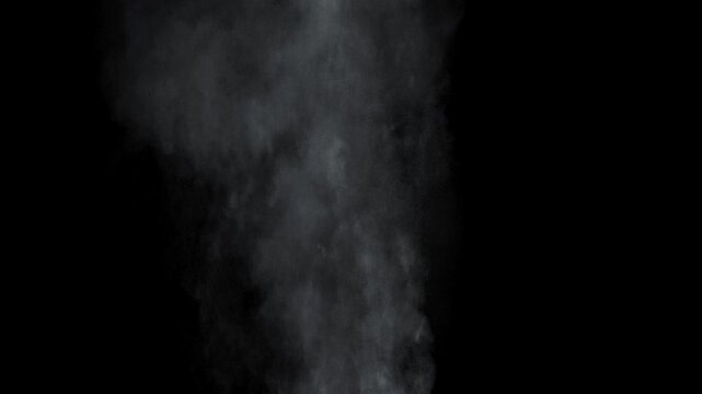 Dusty bullet hits on a wall with chunks of debris flying out . Powder explosion on black background. Impact dust particles. Dust explosion in front of black background, slow-motion close up. 