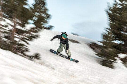Snowboarding on a snowy mountain at sunset