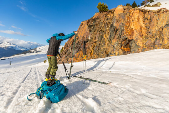 Skier preparing gear on snowy mountain slope