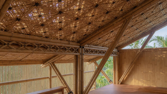 A serene outdoor wooden hut with a thatched roof stands amidst lush greenery in a tropical forest clearing