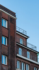 Fototapeta premium Golden Sunset Reflection in Window of Historic Red Brick Facade
