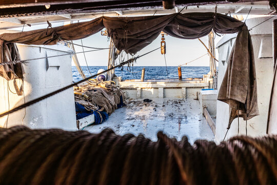 Fishing boat deck with nets and ropes overlooking open sea