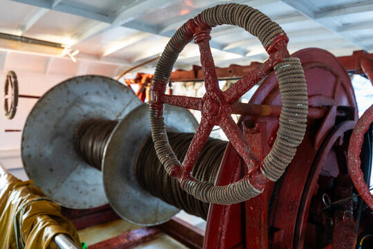 Close-up of ship winch wheel and steel cable spool