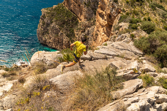 Trail running by the sea on a rocky coastal path