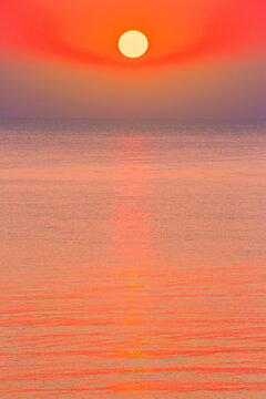 sunrise at the black sea. sun above horizon. reflection on the calm water. nature background in warm orange light