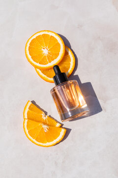 Vitamin C skincare serum bottle with orange slices flat lay