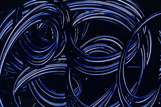 Abstract blue neon light trails on dark background