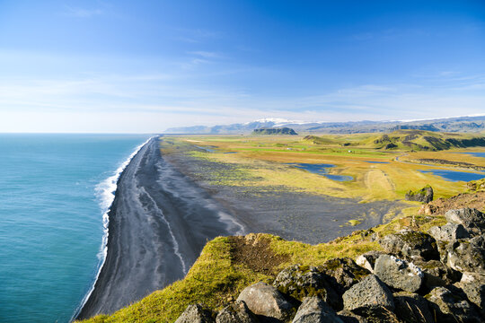Endless black sand beach with turquoise waves