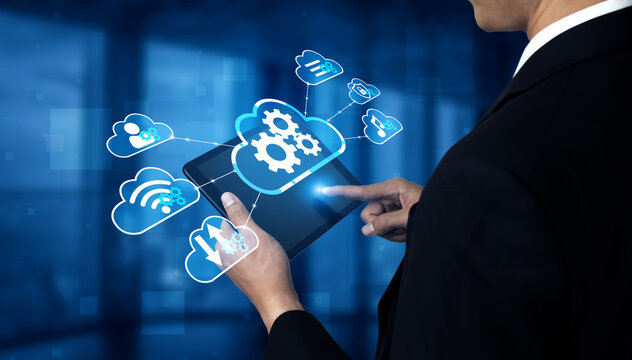 Businessman Using Digital Tablet to Access Cloud Technology and Data Management Solutions in Modern Office Environment with Blue Background. Entropy.