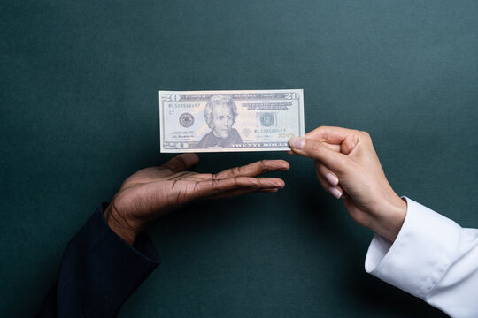 Money exchange between multiethnic hands with cash