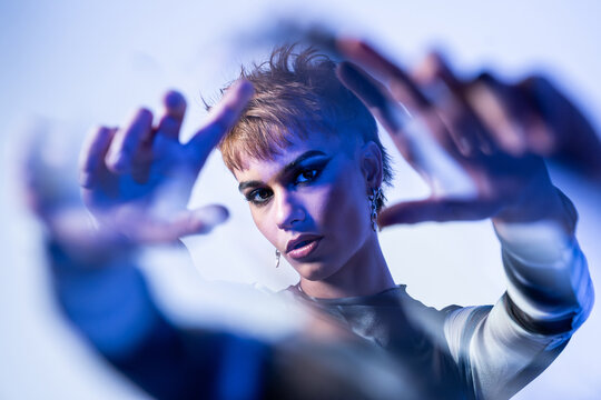 Young fashion model posing in studio with blue light