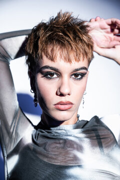Studio portrait of young woman fashion model in silver top