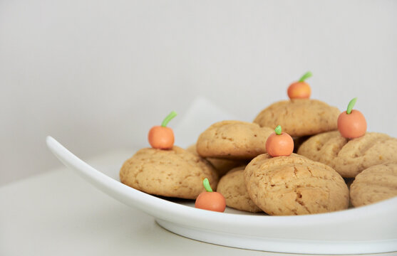 Close-up of a stack of homemade Orange Cookies with orange fondant decorations on a plate