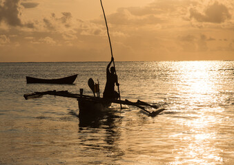 Afrykańscy rybacy ze swoimi drewnianymi katamaranami na plażach Zanzibaru w świetle wschodzącego słońca © kubikactive