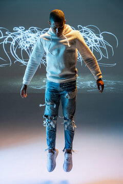 Black man urban dancer floating in neon light streaks