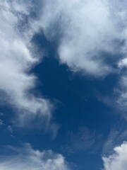 Obraz premium Fluffy clouds in blue sky vertical.