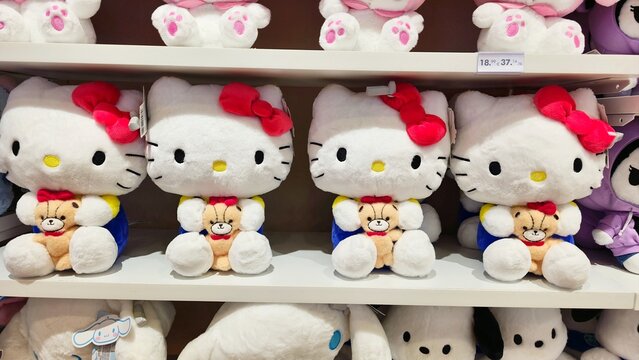 Varna. Bulgaria. 13.07.2026 A store shelf displays several Hello Kitty plush toys with red bows, each holding a small teddy bear accessory, in classic white and red color scheme