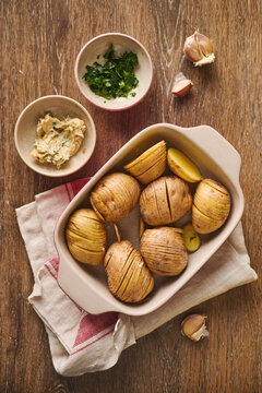Raw Hasselback potatoes in a red ceramic baking dish ready for cooking