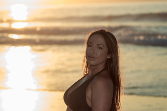 Woman relaxing at beach during golden hour sunset