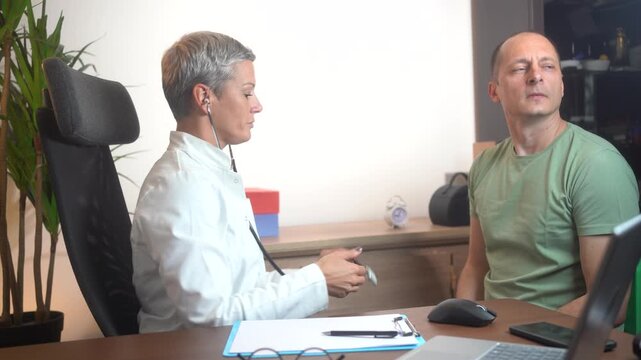 Cardiologist doctor holding stethoscope to listen to middle aged man&rsquo;s heartbeat and lungs sounds. Cardiovascular disease preventive care, regular heart health checkup for adult male patients, cardiol