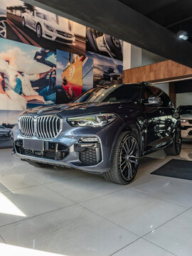 Dark grey BMW X5 front three quarters view, Luxury midsize SUV in indoor showroom