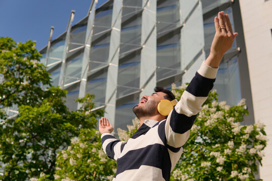 Man with headphones enjoying music outdoors near office