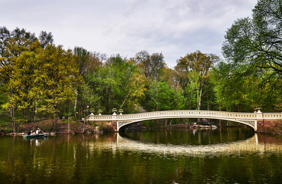 The iconic Bow Bridge in Central Park, New York City, featuring its distinctive cast-iron architecture spanning The Lake