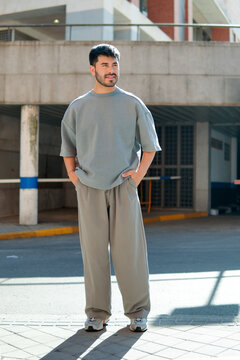 Stylish man in oversized street wear by urban parking garage