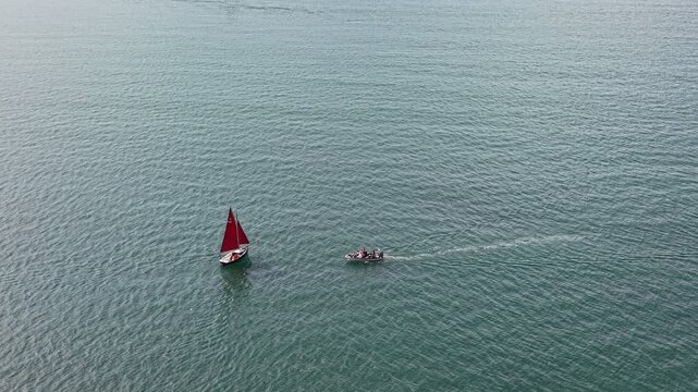 Aerial drone footage of two small boats sailing across vast open water, capturing the sense of scale, solitude, and tranquillity of the surrounding seascape on a bright day