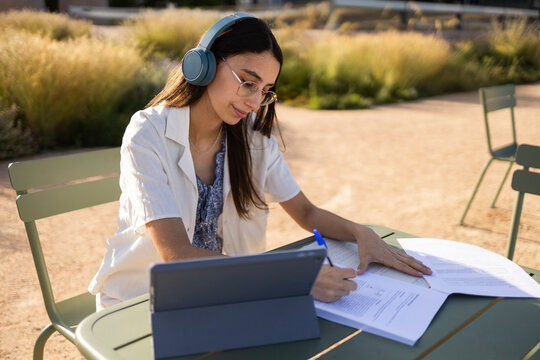 University student studying outdoors on campus with tablet