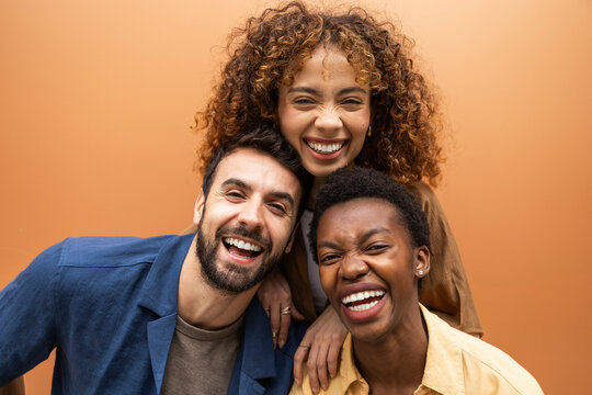Happy diverse friends laughing together in studio portrait