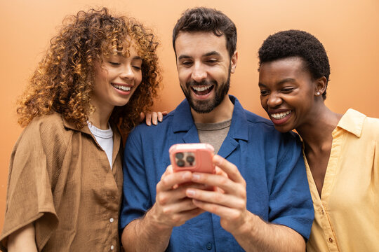 Friends laughing together while looking at a smartphone
