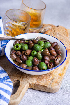 Mediterranean olive appetizer with bread and wine on board