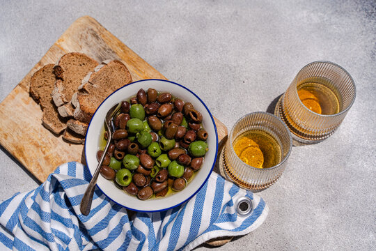 Mediterranean olives with bread and aperitif on table