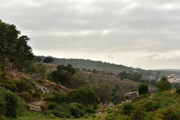 Fototapeta premium Ciel devenant nuageux au dessus d'un paysage semi-aride et rocailleux à Hjar Hennahal au sud de Tanger au Maroc 