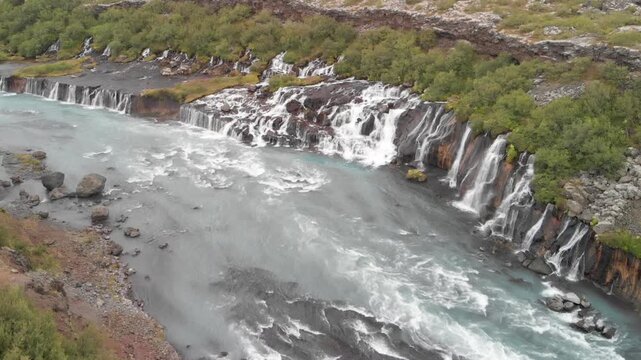 Hraunfossar Waterfalls, Iceland. Aerial view from drone on a summer day. Slow motion