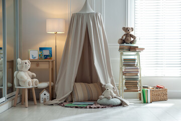 Beautiful wigwam, different toys and books in child's room. Interior design © New Africa