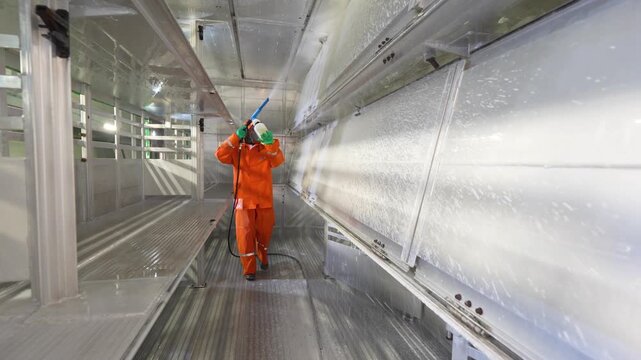 Sanitizing the interior surfaces of a livestock transport trailer with a spray device