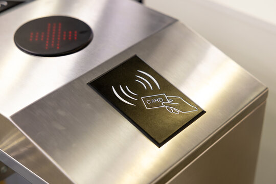 Contactless access control system with card reader on metal turnstile. Modern electronic entrance technology for office security or public transport monitoring. Smart rfid verification device