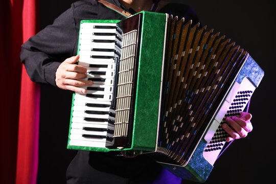Man playing piano accordion on stage, closeup