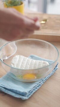 Flour is added to cottage cheese and egg mixture in bowl on kitchen table