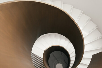 Fototapeta premium Modern spiral staircase design in luxury home interior architecture, showing elegant curved structure, stylish residential space and contemporary design concept with unique architectural details.