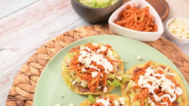 Aerial view of Mexican tostadas with beans, lettuce, chicken, and fresh cheese
