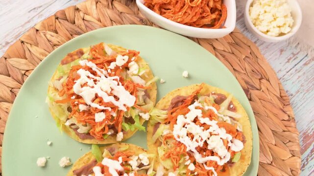 Mexican food. Three crunchy corn tostadas with chicken tinga and refried beans