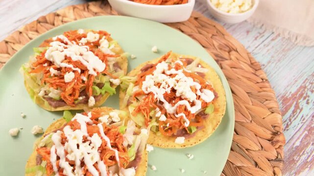 Traditional Mexican tostadas on a green plate. Chicken toasts
