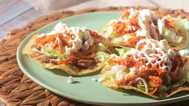 Three authentic Tostadas de Tinga served on a plate with direct flash light. Mexican food