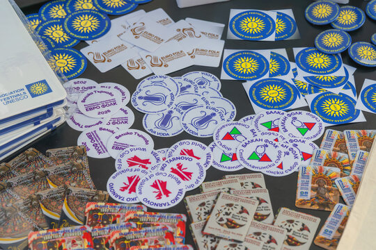 European Association of Folklore Festival merchandise in Pomorie, Bulgaria. Stickers, badges, magnets, promotional merchandise of Folklore Festival, Euro Folk events displayed on table