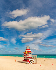 Fototapeta premium Lifeguard over Miami beach. Panoramic seascape of Miamis famous coastline. South Miami Beach. Miami Beach jetty. Rescue tower against the blue sky in Miami. Beautiful coastal view of Florida.