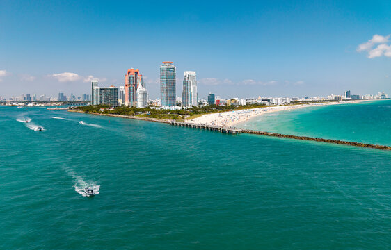 Luxury yacht cruising near Miami skyline. Aerial view of boats on turquoise waters in Miami. Yacht retreat in South Florida Miami. Miami cityscape with sailing vessels. Waterfront panorama.