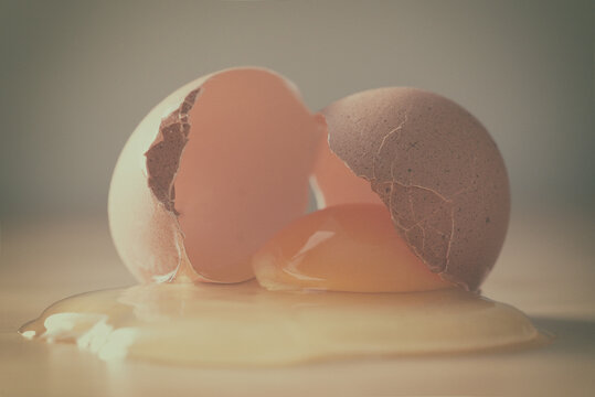 Close-up of a cracked egg and egg shell on a table